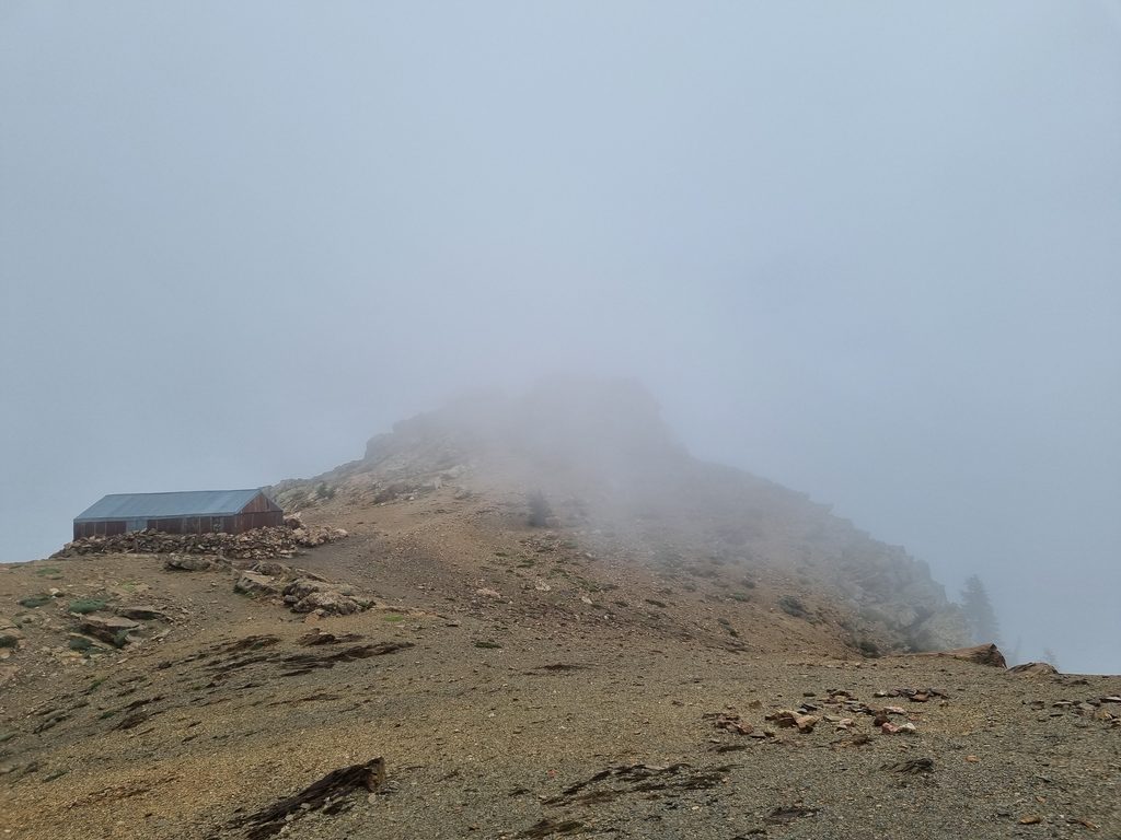 Rotsachtige berghelling bij Jbel Tidighine in het Rifgebergte in Marokko, deels verscholen in de mist.